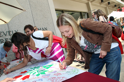 Festival participant Laurie Miller signs the Festival of Life scroll. Photo/Lisa Brook