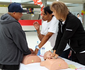 LAC+USC emergency room nurses Cynthia Mitchel (center) and Sandy Montero (right) explain proper technique to a program participant.