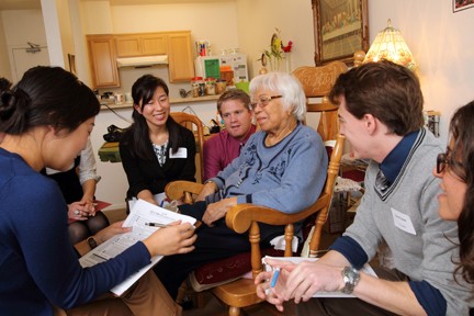 USC students from a range of disciplines — including dentistry, medicine, occupational therapy, pharmacy, physical therapy, physician assistant practice and social work — work together to improve the health care of nonagenarian Filomena Flores, seated center. Photo/Philip Channing