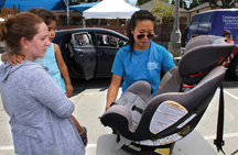 Pictured, Anne Brison, a postdoctoral student at the Zilkha Neurogenetic Institute, and daughter Julia watch as CHLA trauma researcher Ann Lin demonstrates the proper use of a car seat. Photo/Jon Nalick 