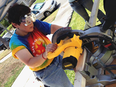 Occupational therapy student Donna Ozawa runs a circular saw to construct a wheelchair ramp for a classmate. Photo/Photo/Courtesy Division of Occupational Science and Occupational Therapy