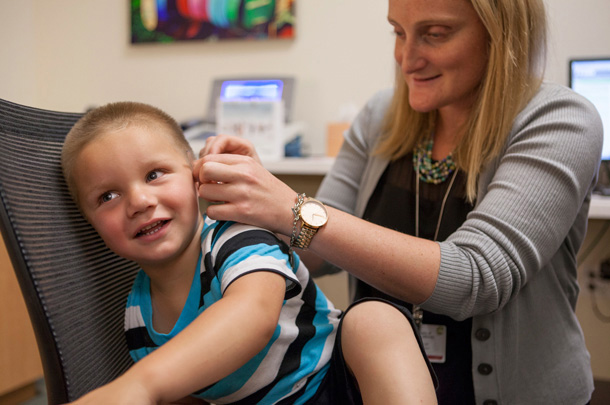 An affiliated treatment center benefits young children with severe hearing loss such as Roman Carbone, shown with audiologist Jamie Glater, AuD.