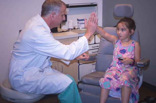Surgeon Rick Friedman exchanges a high five with patient Adrianna Bowman a few days after successful surgery. 
