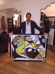 Mike Becker with one of his featured works of art, titled, "Faceman."