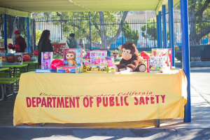 Keck Medicine of USC and USC Department of Public Safety officials bring toys from a holiday toy drive to students from Santa Teresita School on Wednesday, Dec. 16, 2015. (Courtesy/USC Department of Public Safety)