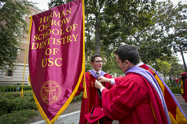 Graduates hold the flag for the Herman Ostrow School of Dentistry during the 133rd Commencement of USC on May 13, 2016 in Los Angeles.