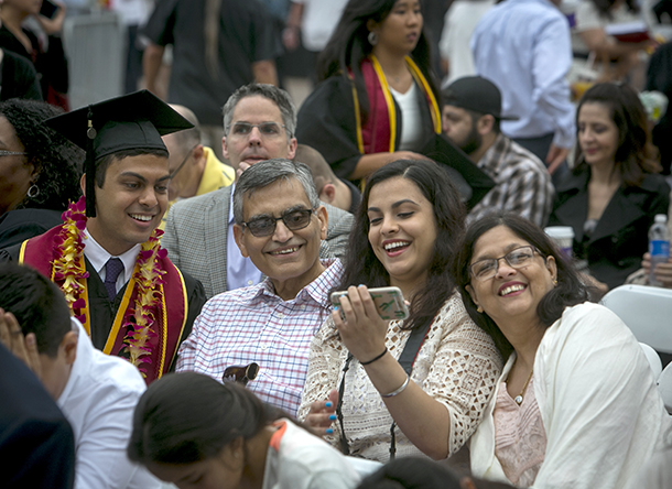 Varun Awasthi, a global health grad, looks over a picture with his family during the 133rd Commencement of USC on May 13, 2016 in Los Angeles.