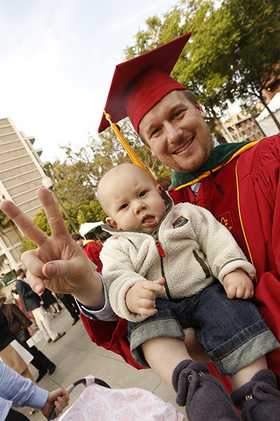 A graduate shows a Victory sign after the Keck School of Medicine of USC MD/PhD and MD commencement ceremony May 14, 2016 at McCarthy Quad on the University Park Campus.