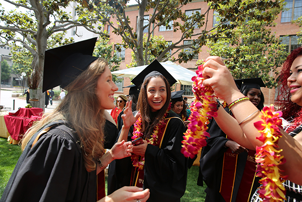 Natasha Germain gets her lei from Melissa Narbona before lining up for the procession at the Primary Care Physician Assistant Program's satellite commencement ceremony May 13, 2016 on the University Park Campus.