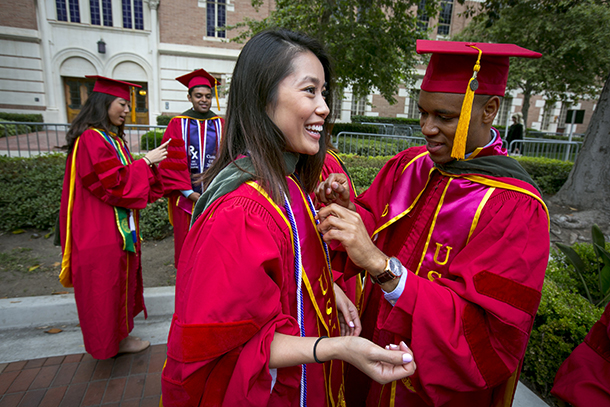 A Doctor of Pharmacy graduate helps fellow USC School of Pharmacy graduate Anh Nguyen with her sash during the 133rd Commencement of USC May 13, 2016 in Los Angeles.