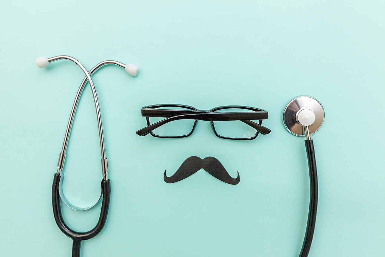 A stethoscope, glasses and fake mustache on an aqua background