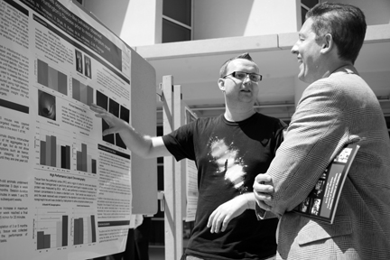 MD/PhD candidate Daniel Stefanko (left) discusses his research poster, “Exercise Ameliorates Depression-like behavior observed in a mouse model of Huntington’s Disease Prior to Motor Symptom Onset” at the annual MD/PhD symposium held on June 13. Photo/Ryan Ball
