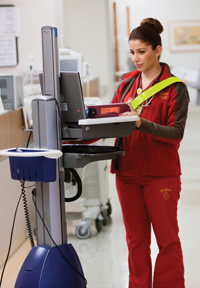 Nurse Amy Zaratsian documents patient information in KeckCare using a WOW, or Workstation on Wheels. Photo/Walter Urie