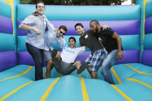 Returning Keck School students Daniel Artenstein, Daniel Furlong, Samuel Hong and Thomas Carter Scotton support Brian Karamian in the bounce house at the Returning Students Welcome Reception, held on Aug. 12. (Photo/Steve Cohn)