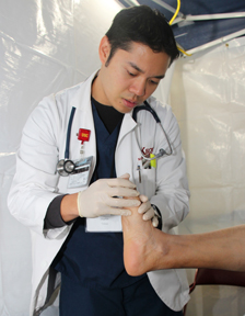 Third-year Keck School of Medicine of USC medical student Martin Tolosa examines a patient at the four-day Care Harbor clinic held Oct. 31 to Nov. 3 at the Los Angeles Memorial Sports Arena. (Photo/Jon Nalick)