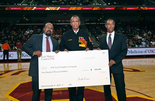 Pictured, Sanjit Mahanti, executive administrator, hospital performance, presents an oversized check to Craig Keys, associate senior vice president for civic engagement, and Tom Sayles, senior vice president for university relations, during a USC basketball game on Feb. 27 at the Galen Center.
