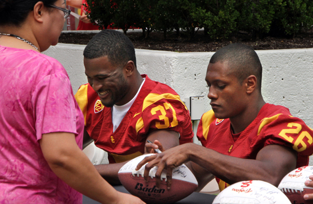 USC football players Javorius Allen and James Toland IV autograph posters and footballs. Photo/Jon Nalick