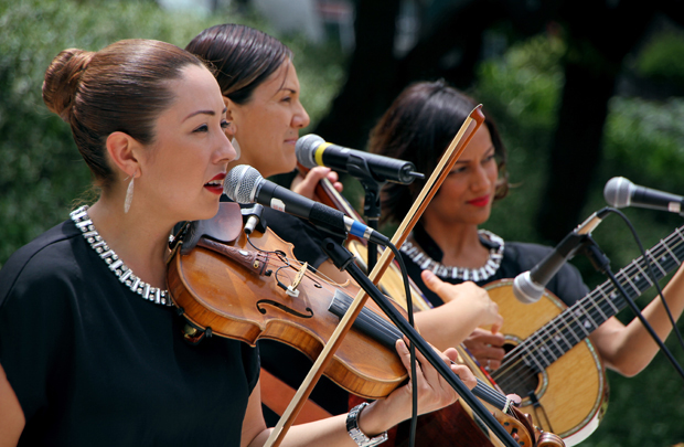 Trio Ellas — (from left) violinist Suemy Gonzalez, guitarrón-player Nelly Cortez and guitarist Stephanie Amaro — play for the lunchtime crowd on Cinco de Mayo. (Photo/Jon Nalick)