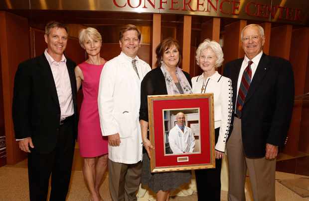 Gathered around the photo of late USC urologist John P. Stein are (from left): his brother Tom Stein; his wife Randi Stein; Stephen B. Gruber, director of the USC Norris Comprehensive Cancer Center; Jane Centofante; and Stein’s parents Helen Mary and Robert Stein. (Photo/Steve Cohn)