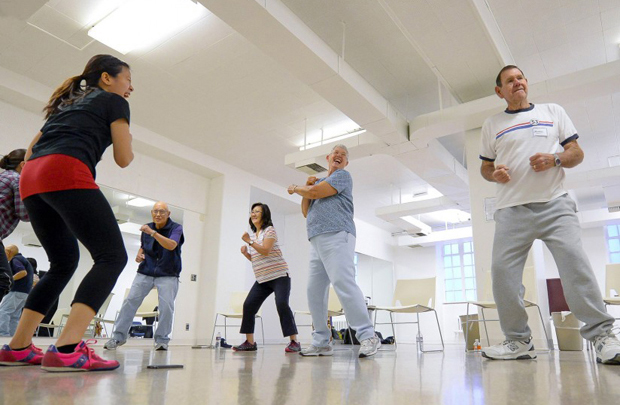 Workout instructors lead Kenneth Yokoyama, Pauline Beavers, Barbara Counsil and Richard Counsil, from left, through their exercise class. (USC Photo/Gus Ruelas)