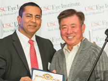 USC Eye Institute Director Rohit Varma, MD, MPH, accepts a letter of commendation from Arcadia Mayor John Wuo at the grand opening of the institute's Arcadia clinic on Dec. 1, 2014.