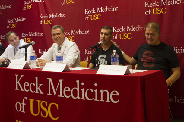 In gratitude, liver transplant recipient Jorge Castro places a hand on the shoulder of fellow sheriff's deputy and organ donor Javier Tiscareno during a June 11 news conference with doctors Saro Khemichian and Yuri Genyk of Keck Medicine of USC. 