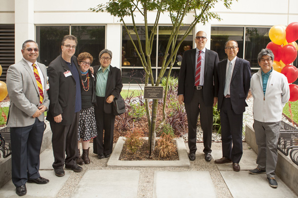 CEO Tom Jackiewicz of Keck Medicine of USC joins Adrian and Kathy Rudnyk, standing arm-in-arm, and others who helped refurbish the garden near the administrative offices at Keck Hospital of USC.