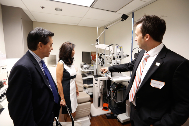 Michael Quon, Jacqueline Quon and Damien Rodger, MD, PhD, discuss some of he equipment that is used at the USC Eye Institute facility in Beverly Hills.