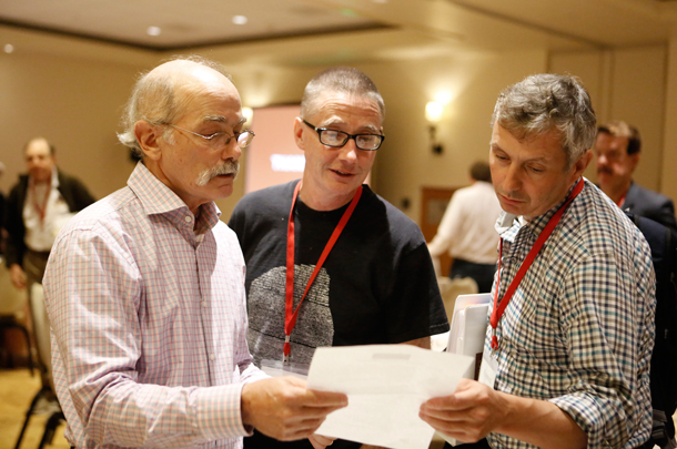 Arthur Toga of the USC Stevens Neuroimaging and Informatics Institute and USC Stem Cell’s Andrew McMahon check an agenda with Raymond Stevens of the Bridge Institute at USC Dornsife.