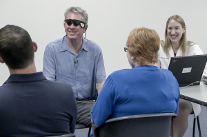 Terry Byland wears the Argus II device as he speaks with physician Lisa Olmos de Koo of the USC Eye Institute, along with his wife Sue and son Daniel. (photo Alison Trinidad)