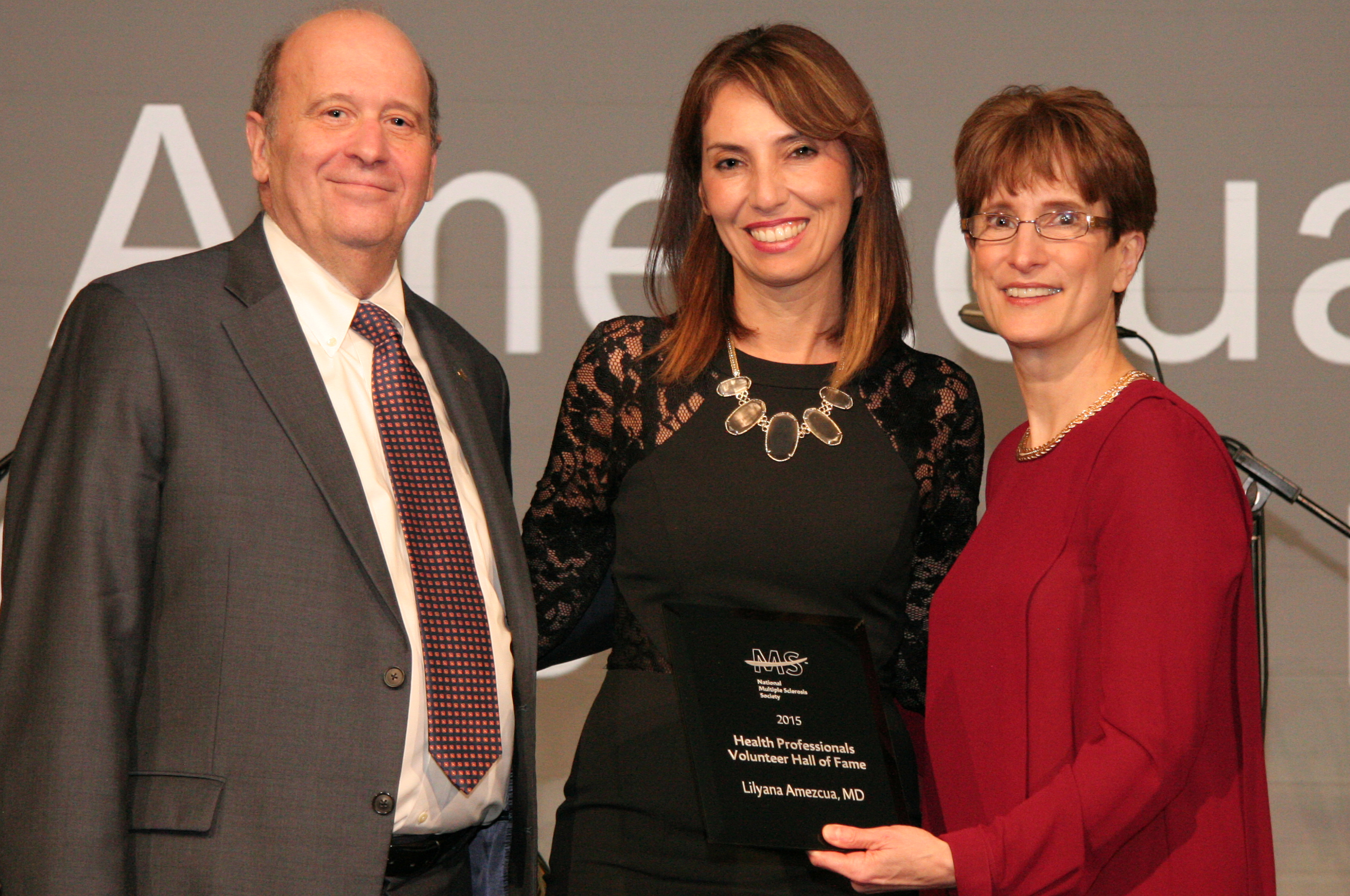 Lilyana Amezcua, center, receives her award from National MS Chairman of the Board Eli Rubenstein and President and CEO Cynthia Zagieboylo. 