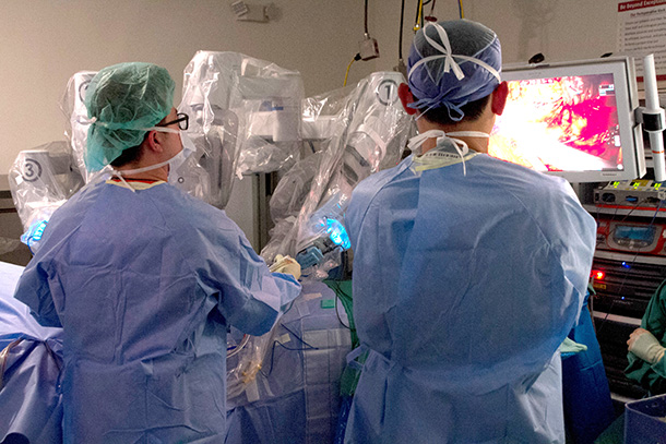 Members of the medical team watch a robot-assisted spinal tumor surgery with Patrick Hsieh, MD, and Andrew Hung, MD.