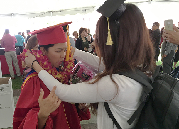 Anna Loraine Agustin Escobedo, a Keck School of Medicine of USC doctor of philosophy graduate in preventive medicine/epidemiology, is given a flower lei after commencement on May 14, 2016.