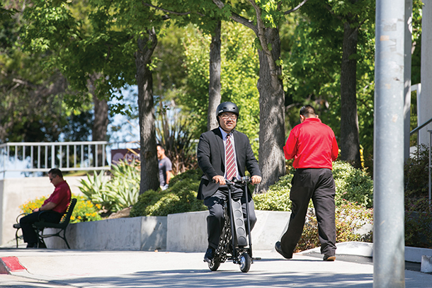 Eric Chang rides an URB-E, a foldable electric scooter, down Eastlake Avenue on the Health Sciences Campus.