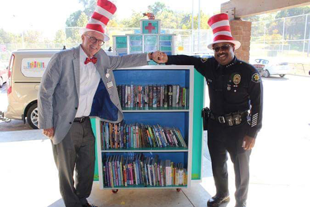 Paul Craig, left, and USC Department of Public Safety Chief John Thomas are seen at the opening of the Little Library. The Little Library is a custom-built large hospital library stocked with new books for community youth.