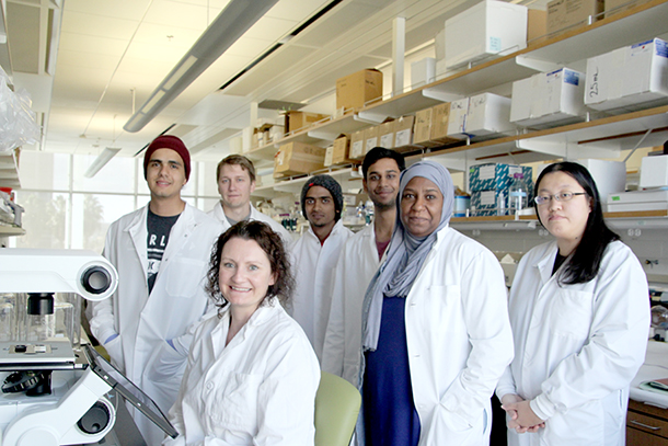 Amy Firth, seated, is surrounded by members of her lab.