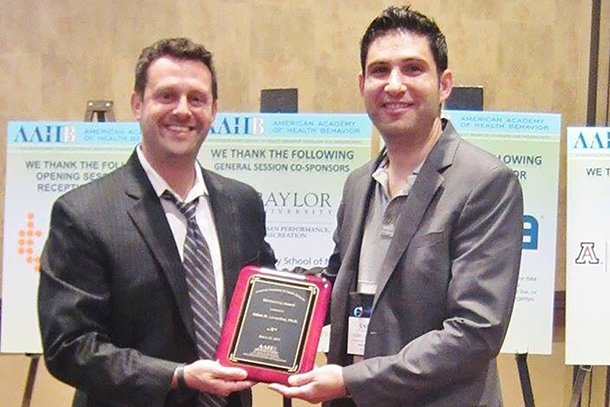 Adam Leventhal, right, accepts the 2017 American Academy of Health Behavior (AAHB) Mentorship Award on March 22 in Arizona.