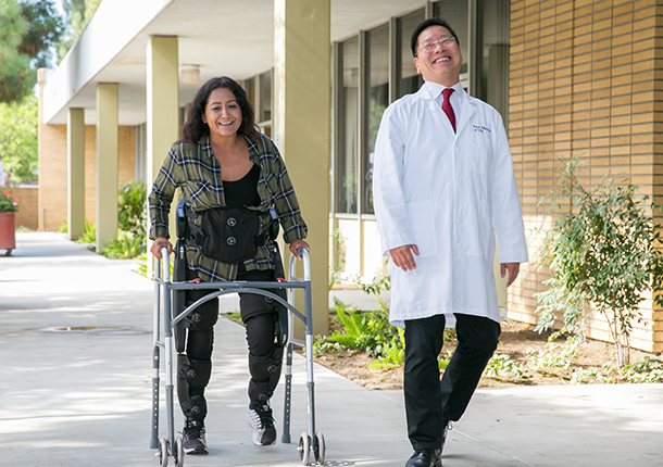 Cynthia Ramirez and Charles Liu test a robotic exoskeleton similar to one being developed by the National Science Foundation grant project.