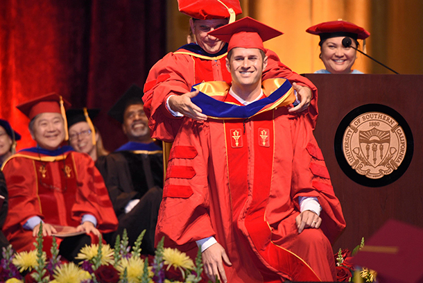 A PhD candidate is hooded during the 13th Keck School of Medicine of USC commencement ceremony for PhD, Master of Science and Master of Global Health graduates, held May 12 at the Galen Center.