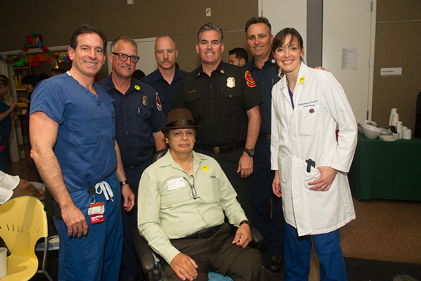 Marc Eckstein, left, and Elizabeth Benjamin, right, reunite with Hector Ruiz, center, and members of the Alhambra Fire Department during the Trauma Survivors Reunion on May 5.