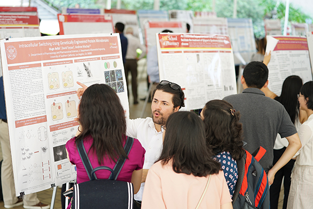 Student attendees present their research in a poster competition.