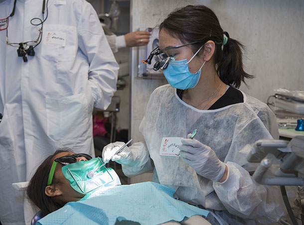 Dental student Tuongvi “Tiffany” Mai works on patient Karla Hernandez during a USC Mobile Clinic event.