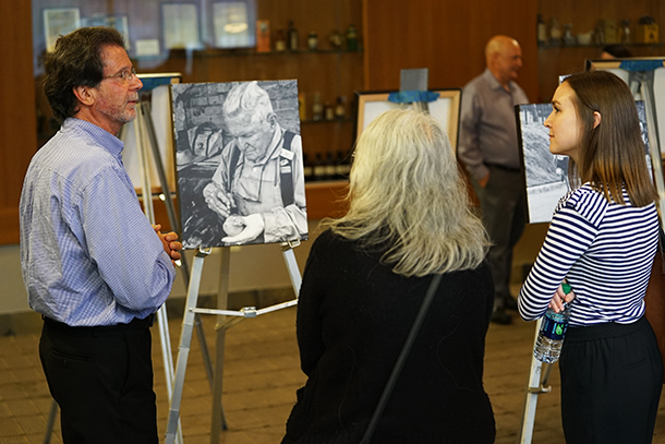 Bradley Williams, left, speaks with guests at his gallery exhibition on Sept. 25, made possible through the USC Office of the Provost’s Early Retirement Program.