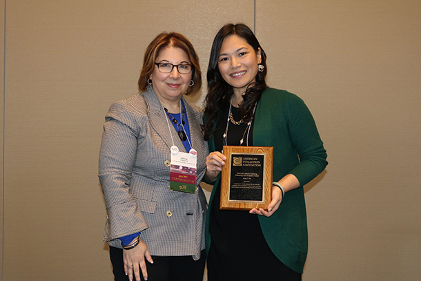 Anne Vo, right, receives the 2018 AEA Marcia Guttentag Promising New Evaluator Award from the American Evaluation Association.