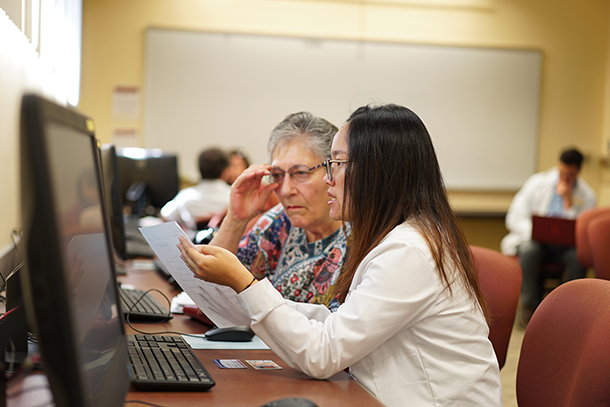 Second-year PharmD student Anh Vo helps a USC retiree select a prescription drug coverage plan during Medicare Part D Enrollment Week.