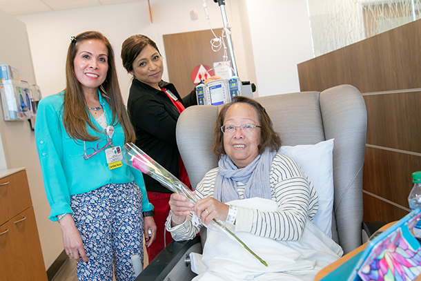 Nurse Manager Rotch Delos Santos, left, and Nurse Juanita Gaona, rear center, give patient Anita Louie a Mother's Day Rose.