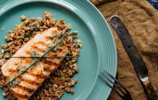 A salmon filet rests on a bed of whole grains.