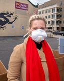 A blonde woman wears a protective mask.