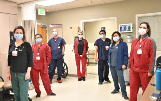 Clinicians wearing protective masks stand in a V formation.