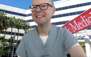 A man smiles in front of a virtual background depicting a hospital.